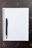 15536016-cuaderno-en-blanco-y-un-bolígrafo-negro-sobre-la-mesa.jpg