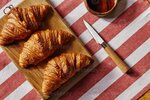 three-french-freshly-baked-croissants-on-wooden-plate-with-honey-photo.jpg