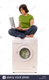 woman-in-green-top-sitting-cross-legged-on-domestic-washing-machine-B33TA0.jpg