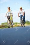 58326918-dos-personas-mayores-sonriente-que-monta-en-bicicleta-en-verano-en-un-carril-bici.jpg