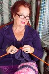 23467085-red-señora-mayor-pelo-mirando-mientras-tejer-la-bufanda-púrpura-ella-está-usando-ropa...jpg