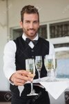 27141536-oferta-de-camarero-guapo-copa-de-champán-en-el-patio-del-restaurante.jpg